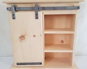 Unfinished Sliding Barn Door Cabinet. Measures: 26" x 9 1/4" x 25 1/2".  Door Slides on Metal Rail.