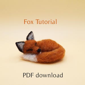 May include: A PDF download tutorial for needle felting a sleeping fox. The fox is curled up with its tail wrapped around its body. The fox is orange with a white tip on its tail and black eyes.