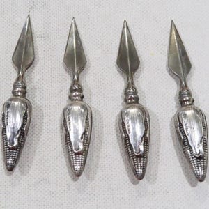 May include: Four silver corn cob shaped cocktail picks with a pointed tip.