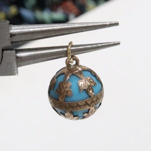 Antique turquoise glass orb covered in a 10K floral wrap with a 14K bail