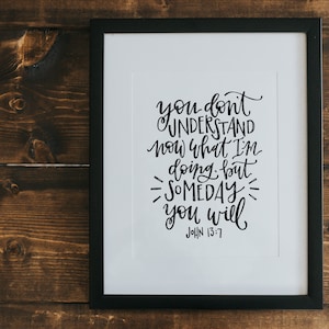 May include: A black framed print with a white background and black calligraphy text that reads "you don't understand now what I'm doing but someday you will John 13:7".