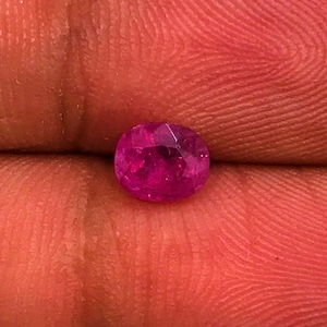 May include: A vibrant pink gemstone with a round cut and a faceted surface.