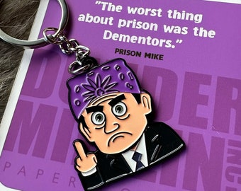 May include: A purple and black metal keychain featuring a cartoon character with a purple bandana and the text "Prison Mike" and "The worst thing about prison was the Dementors."
