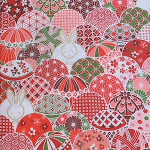 Könnte beinhalten: Roter, weißer und grüner Stoff mit einem sich wiederholenden Muster aus japanischen Glücksbringern, Blumen und Kaninchen. Der Stoff ist perfekt zum Quilten, Basteln und Dekorieren.