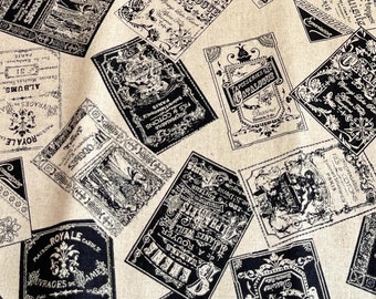 May include: Beige fabric with a black and white repeating pattern of vintage labels. The labels feature ornate designs and text in French.