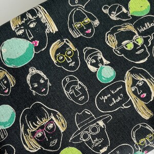 以下が含まれることがあります： 白い線で描かれた眼鏡をかけた人々と吹き出しが繰り返されるパターンが施された黒い布。吹き出しには「hello」「you know what?」「I'll show you」などのテキストが書かれている。