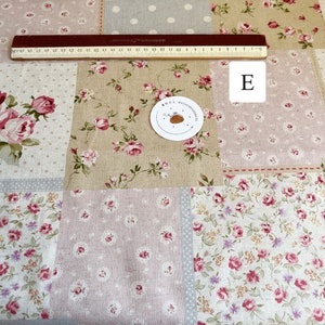 Pode incluir: Tecido patchwork com um padrão floral em tons de rosa, bege e cinza. O tecido apresenta uma variedade de desenhos florais, incluindo rosas pequenas, rosas maiores e bolinhas. O tecido é perfeito para acolchoar, costurar e artesanato.