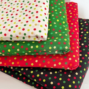 以下が含まれることがあります： 赤、緑、黒、白のドット柄の生地が4枚。生地は重ねて折り畳まれています。