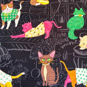 May include: Black fabric with a repeating pattern of colourful cats wearing clothes and hats. The fabric has a chalkboard-like background with handwritten text that says "miracle of moments" and "shape of happiness".
