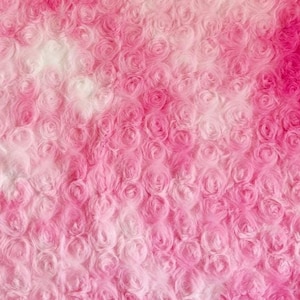 Könnte beinhalten: Nahaufnahme eines rosa-weißen Kunstpelzes mit einer rosenartigen Textur. Der Stoff hat einen Farbverlauf von Weiß nach Rosa. Der Text "3. Pink" ist in der oberen rechten Ecke des Bildes sichtbar.