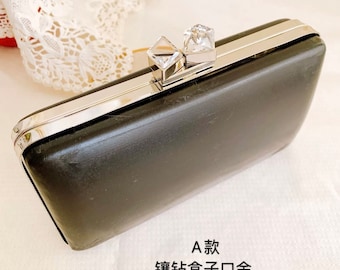 Può includere: Una pochette nera con una chiusura argentata e due decorazioni di cristallo. La pochette misura 5,4 cm x 9,8 cm x 17,8 cm.