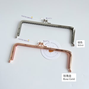 May include: Two purse frames, one silver and one rose gold. The frames are open and ready to be used for a purse or wallet.