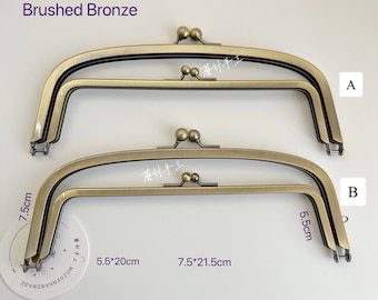 May include: Two brushed bronze purse frames, one measuring 7.5 inches by 21.5 inches and the other measuring 5.5 inches by 20 inches.