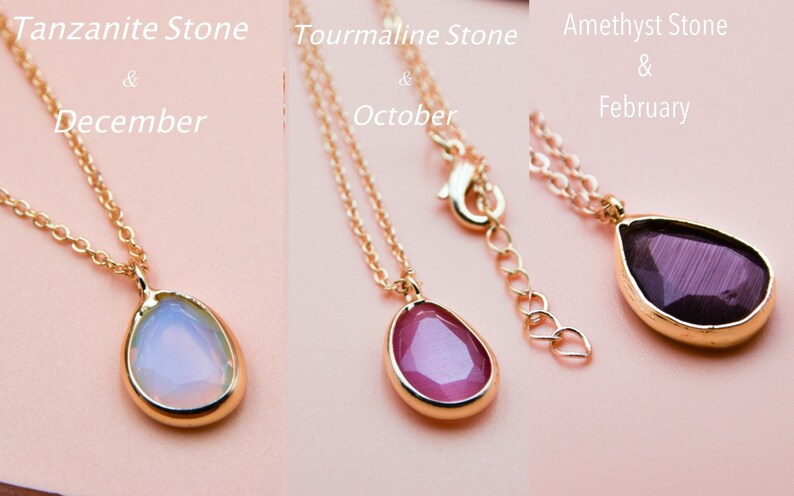 May include: Three gold necklaces with teardrop-shaped pendants. The pendants are made of tanzanite, tourmaline, and amethyst stones. The tanzanite stone is light blue, the tourmaline stone is pink, and the amethyst stone is purple. The necklaces are labeled with the stone name and the corresponding birth month: Tanzanite Stone & December, Tourmaline Stone & October, Amethyst Stone & February.