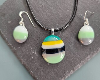 Colgante y pendientes de tiras de cristal con diseño de caramelo en tonos verdes y grises.