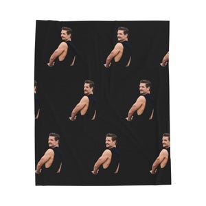 May include: A black blanket featuring a repeating pattern of a man in a black tank top, turned to the side with a mustache. The background is solid black.