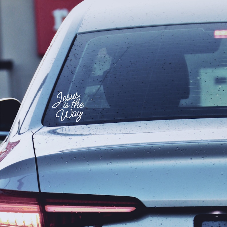 A picture showing the rear of a vehicle with a white sticker decal saying, "Jesus is the Way".