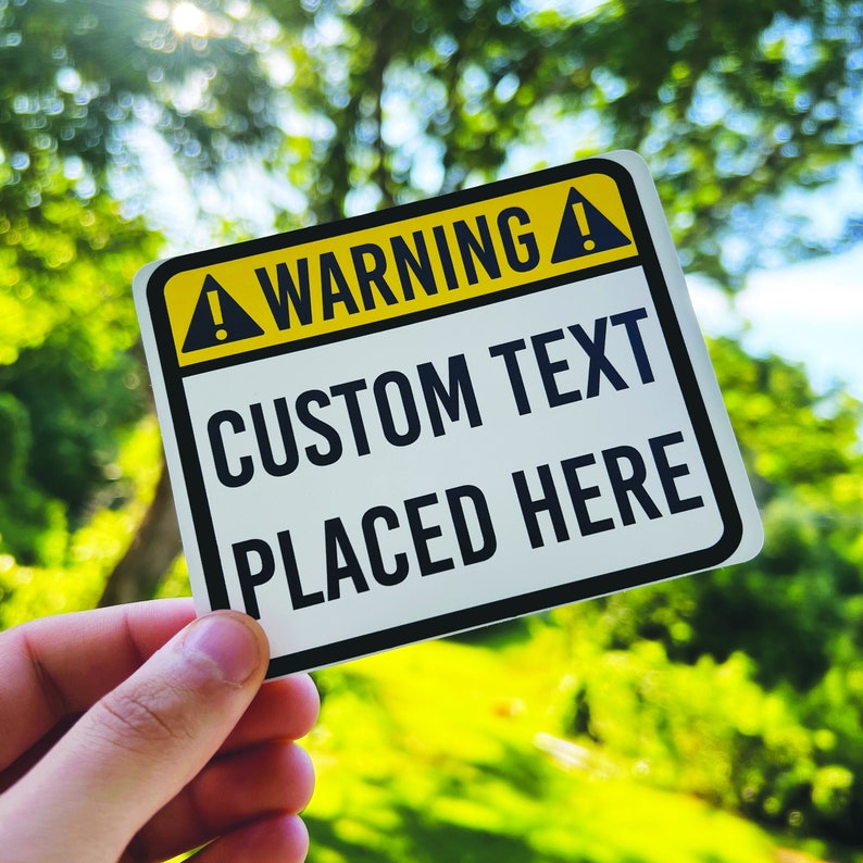 May include: A yellow and black warning sign with the text "WARNING!" and "CUSTOM TEXT PLACED HERE".