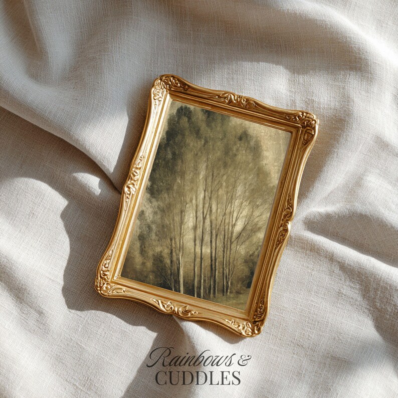 Peut inclure: Un cadre photo rectangulaire dor&eacute; avec des d&eacute;tails en relief ornementaux sur les bords. Le cadre contient une impression repr&eacute;sentant un groupe d'arbres hauts et fins dans des tons terreux sourds de brun, beige et vert fonc&eacute; sur un fond doux.