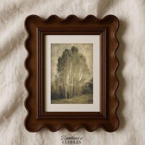 Peut inclure: Un cadre photo rectangulaire avec une finition en bois brun fonc&eacute; et un bord ondul&eacute; en forme de feston. Le cadre contient une impression de paysage montrant un groupe d'arbres hauts et fins dans des tons s&eacute;pia. Le texte Rainbows & Cuddles est visible.
