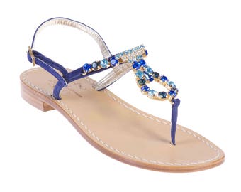 May include: Blue leather sandals with a gold and blue jeweled strap.
