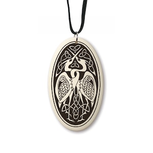 May include: A white ceramic pendant with a black and white design of two birds intertwined in a Celtic knot. The pendant is attached to a black cord.