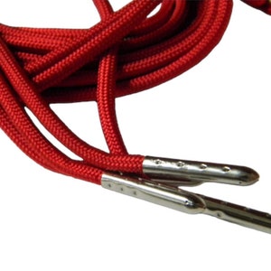 May include: Red shoelaces with silver metal aglets. The shoelaces are made of a thick, durable material and are perfect for adding a pop of color to any shoe.