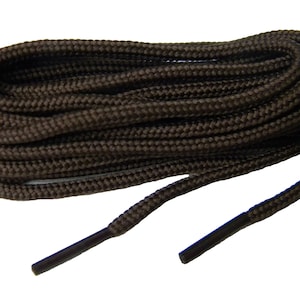 May include: A coiled pair of dark brown shoelaces with a woven, textured surface. Each end of the shoelace features a solid, smooth dark brown plastic aglet, providing a clean finish to the durable, round cord construction of the laces.