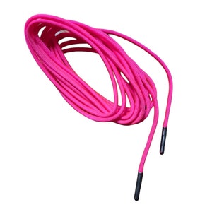 May include: A pair of bright pink shoelaces with black aglets. The shoelaces are coiled together.