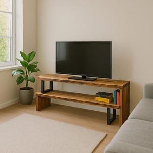 May include: A wooden TV stand with a live edge design, featuring a black flat-screen television. The stand has two shelves and black metal legs. Two books and a plant are visible.