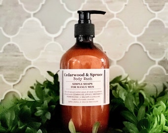 Może przedstawiać: Brązowa butelka żelu do kąpieli Cedarwood & Spruce z czarną pompką. Butelka jest oznaczona jako "Simple Soaps for Manly Men" i zawiera listę składników: cedr, świerk, jodła syberyjska, kadzidło i balsam olejki eteryczne.