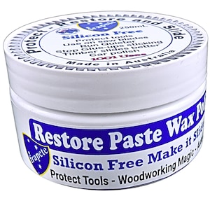 May include: A white jar with a blue label that reads "Restore Paste Wax Polish". The label also says "Silicon Free Make it slide" and "Protect Tools - Woodworking Magic".