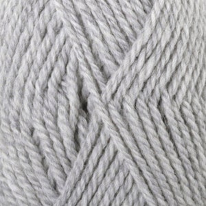May include: Close-up of a skein of light gray yarn. The yarn is tightly twisted, showing a textured surface. The fibers are thick and appear soft, suitable for knitting or crocheting projects. The color is a neutral, versatile shade.