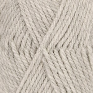 May include: Close-up of a skein of light gray yarn. The yarn has a thick, textured appearance, with visible fibers and a slightly twisted structure. The color is a neutral, soft gray, suitable for various knitting or crochet projects.