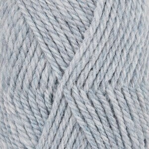 May include: Close-up of a skein of light blue yarn. The yarn has a textured appearance with visible fibers and a slight marled effect. The yarn is tightly wound, showing the individual strands. Ideal for knitting and crochet projects.