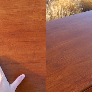 Puede incluir: Primer plano de una superficie de madera lisa de color marr&oacute;n oscuro. La veta de la madera es visible y la superficie parece pulida.