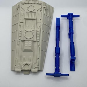 Peut inclure: Un composant en plastique gris clair de forme trapézoïdale avec des détails géométriques moulés complexes, accompagné de deux tiges en plastique bleu vif distinctes et fines avec des extrémités en T, pièces modulaires pour assemblage.