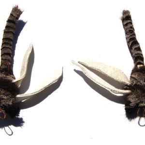 Może przedstawiać: Dwa brązowe i białe przynęty muchowe z pi&oacute;ropuszami i białymi skrzydłami.