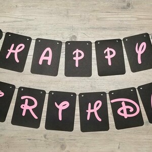 May include: Black and pink banner with the words "Happy Birthday" and two Minnie Mouse heads on either end.