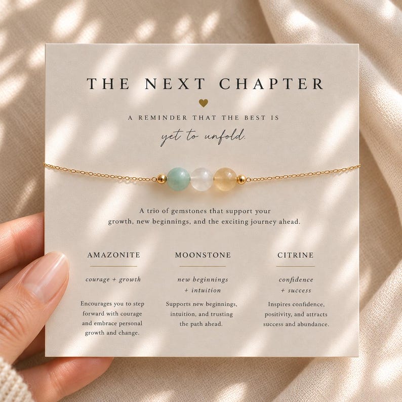 May include: A delicate gold-tone chain bracelet featuring three round beads: a light green amazonite, a translucent moonstone, and a pale yellow citrine. The bracelet is displayed on a cream-colored card with the text THE NEXT CHAPTER.