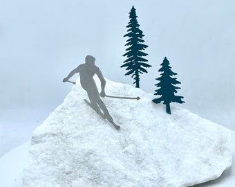 Skiing sculpture. This skiing scene catches the eye with a marble base and stainless steel skier and trees. Mantel or tabletop decor