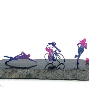 Black stone with stainless steel swim bike run figures.  Galaxy powder coat and 140.6 mile marker.