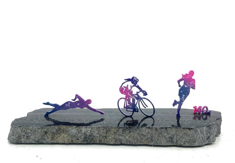 Black stone with stainless steel swim bike run figures.  Galaxy powder coat and 140.6 mile marker.