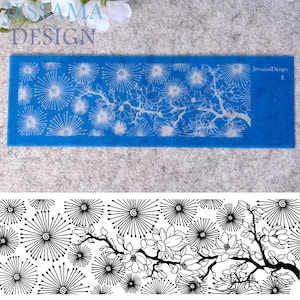 May include: A rectangular blue screen printing stencil featuring a detailed pattern of radiating starburst shapes and a flowering branch with blossoms. The text JessamaDesign and the number 8 are printed in the top right corner of the stencil.