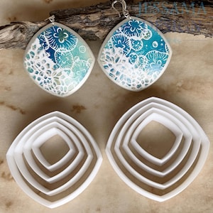 May include: Handmade diamond-shaped earrings with a white lace design over a blue and turquoise background. Two sets of white, square-shaped polymer clay cutters are also shown, ideal for crafting jewellery.