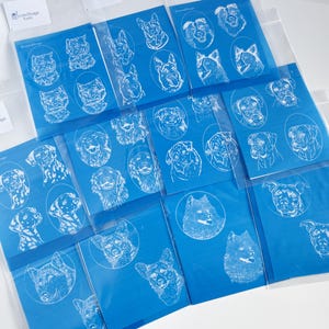 May include: A selection of blue cards with white line drawings of different dog breeds. Each card displays several dog portraits. The cards are packaged in clear plastic sleeves. The text "Personalized Design Tools" is visible on a label.