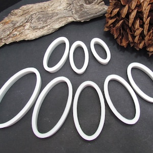 May include: Set of eight white oval-shaped cookie cutters of varying sizes.