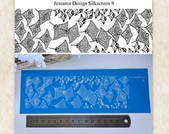 May include: A blue rectangular silkscreen stencil featuring a repeating pattern of white stingrays. The text JessamaDesign 9 is printed on the right side. A metal ruler is positioned below the stencil, showing a length of 15 centimetres.