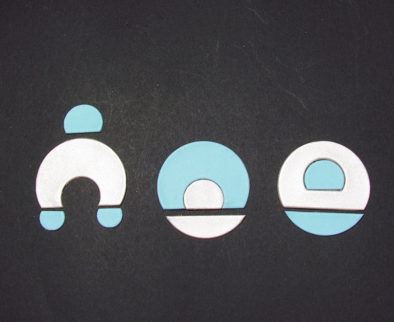 May include: Three abstract geometric shapes in blue and white. The shapes are a horseshoe, a circle with a smaller circle inside, and a circle with a smaller circle cut out.