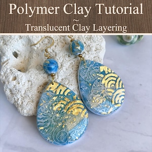 May include: A pair of teardrop-shaped polymer clay earrings featuring a blue and white marbled pattern with gold leaf accents. Each earring has a round bead at the top and a gold-toned hook. The text Polymer Clay Tutorial Translucent Clay Layering is visible.